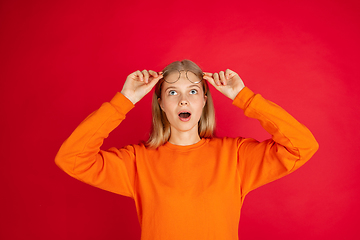 Image showing Portrait of young caucasian woman with bright emotions isolated on red studio background