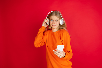 Image showing Portrait of young caucasian woman with bright emotions isolated on red studio background