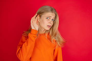 Image showing Portrait of young caucasian woman with bright emotions isolated on red studio background