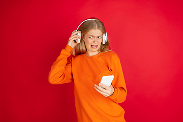 Image showing Portrait of young caucasian woman with bright emotions isolated on red studio background