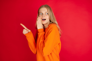 Image showing Portrait of young caucasian woman with bright emotions isolated on red studio background