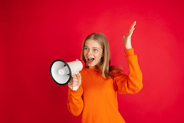 Image showing Portrait of young caucasian woman with bright emotions isolated on red studio background