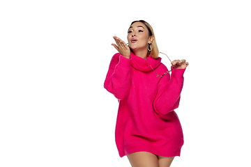 Image showing Beautiful young woman in bright pink comfortable sweater, long sleeve isolated on white studio background