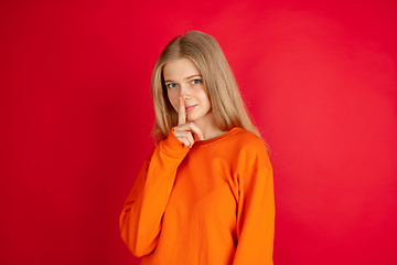 Image showing Portrait of young caucasian woman with bright emotions isolated on red studio background