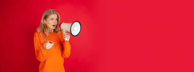 Image showing Portrait of young caucasian woman with bright emotions isolated on red studio background