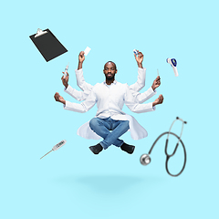 Image showing Handsome multi-armed doctor levitating isolated on blue studio background with equipment