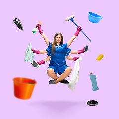 Image showing Handsome multi-armed housemaid levitating isolated on pink studio background with equipment