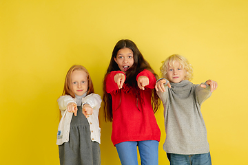 Image showing Portrait of little caucasian children with bright emotions isolated on yellow studio background