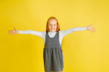 Image showing Portrait of little caucasian girl with bright emotions isolated on yellow studio background