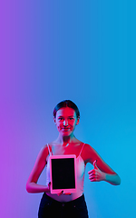 Image showing Young caucasian woman\'s portrait on gradient blue-purple studio background in neon light