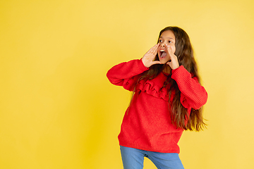 Image showing Portrait of young caucasian teen girl with bright emotions isolated on yellow studio background