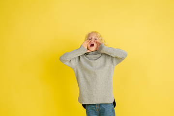 Image showing Portrait of little caucasian boy with bright emotions isolated on yellow studio background