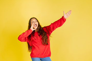 Image showing Portrait of young caucasian teen girl with bright emotions isolated on yellow studio background