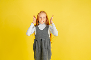 Image showing Portrait of little caucasian girl with bright emotions isolated on yellow studio background