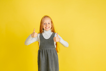 Image showing Portrait of little caucasian girl with bright emotions isolated on yellow studio background