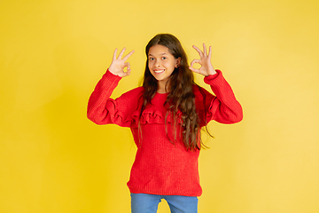 Image showing Portrait of young caucasian teen girl with bright emotions isolated on yellow studio background