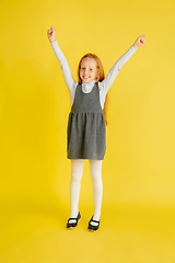 Image showing Portrait of little caucasian girl with bright emotions isolated on yellow studio background