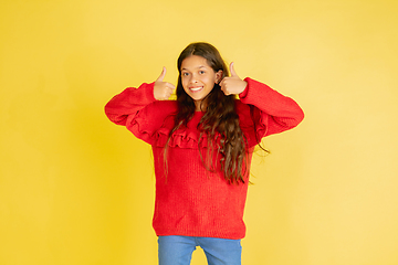 Image showing Portrait of young caucasian teen girl with bright emotions isolated on yellow studio background