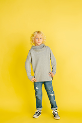 Image showing Portrait of little caucasian boy with bright emotions isolated on yellow studio background