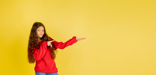 Image showing Portrait of young caucasian teen girl with bright emotions isolated on yellow studio background