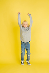 Image showing Portrait of little caucasian boy with bright emotions isolated on yellow studio background