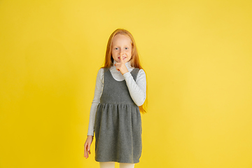 Image showing Portrait of little caucasian girl with bright emotions isolated on yellow studio background