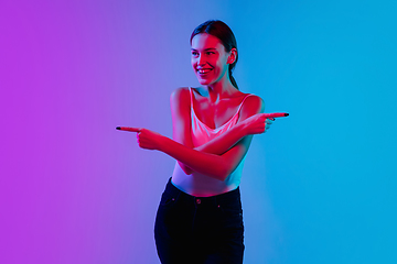 Image showing Young caucasian woman\'s portrait on gradient blue-purple studio background in neon light