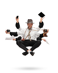 Image showing Handsome multi-armed journalist levitating isolated on yellow studio background with equipment