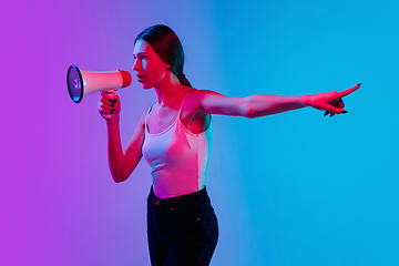 Image showing Young caucasian woman\'s portrait on gradient blue-purple studio background in neon light