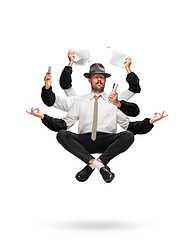 Image showing Handsome multi-armed journalist levitating isolated on yellow studio background with equipment