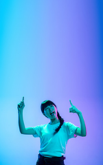 Image showing Young asian woman\'s portrait on gradient blue-purple studio background in neon light