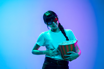 Image showing Young asian woman\'s portrait on gradient blue-purple studio background in neon light