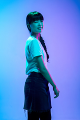 Image showing Young asian woman\'s portrait on gradient blue-purple studio background in neon light