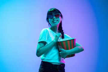 Image showing Young asian woman\'s portrait on gradient blue-purple studio background in neon light