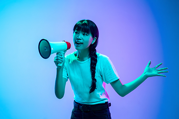 Image showing Young asian woman\'s portrait on gradient blue-purple studio background in neon light