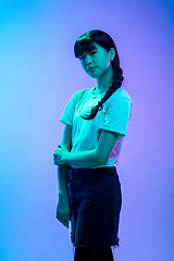 Image showing Young asian woman\'s portrait on gradient blue-purple studio background in neon light