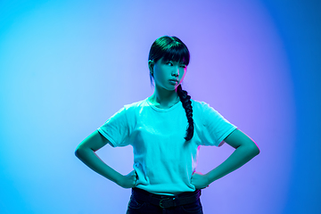 Image showing Young asian woman\'s portrait on gradient blue-purple studio background in neon light