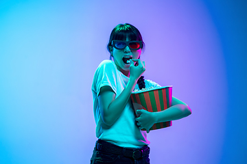 Image showing Young asian woman\'s portrait on gradient blue-purple studio background in neon light