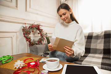 Image showing Woman opening, recieving greeting card for New Year and Christmas 2021 from friends or family