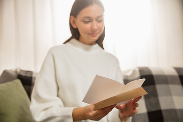 Image showing Woman opening, recieving greeting card for New Year and Christmas 2021 from friends or family