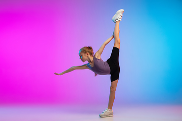 Image showing Teenage girl running, jogging against gradient pink-blue neon studio background in motion