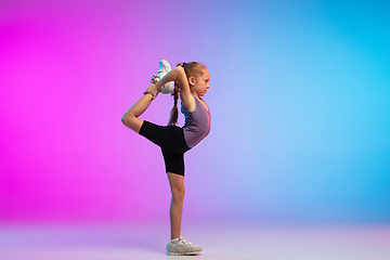 Image showing Teenage girl running, jogging against gradient pink-blue neon studio background in motion