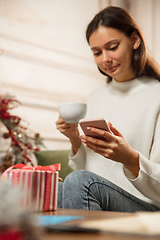 Image showing Woman writing message, greetings for New Year and Christmas 2021 for friends or family with her cellphone