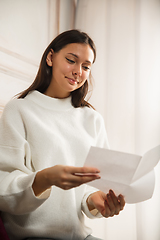 Image showing Woman opening, recieving greeting card for New Year and Christmas 2021 from friends or family