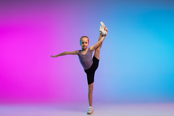 Image showing Teenage girl running, jogging against gradient pink-blue neon studio background in motion