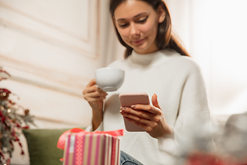 Image showing Woman writing message, greetings for New Year and Christmas 2021 for friends or family with her cellphone