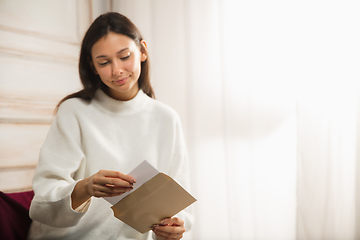 Image showing Woman opening, recieving greeting card for New Year and Christmas 2021 from friends or family