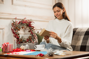 Image showing Woman opening, recieving greeting card for New Year and Christmas 2021 from friends or family