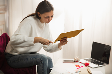 Image showing Woman opening, recieving greeting card for New Year and Christmas 2021 from friends or family