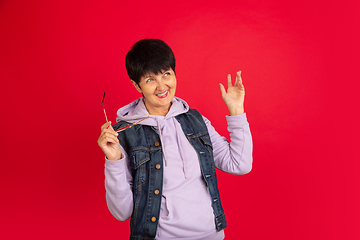 Image showing Senior woman isolated on red background. Tech and joyful elderly lifestyle concept